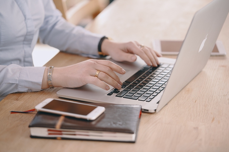 weibliche Person tippt auf Laptoptastatur